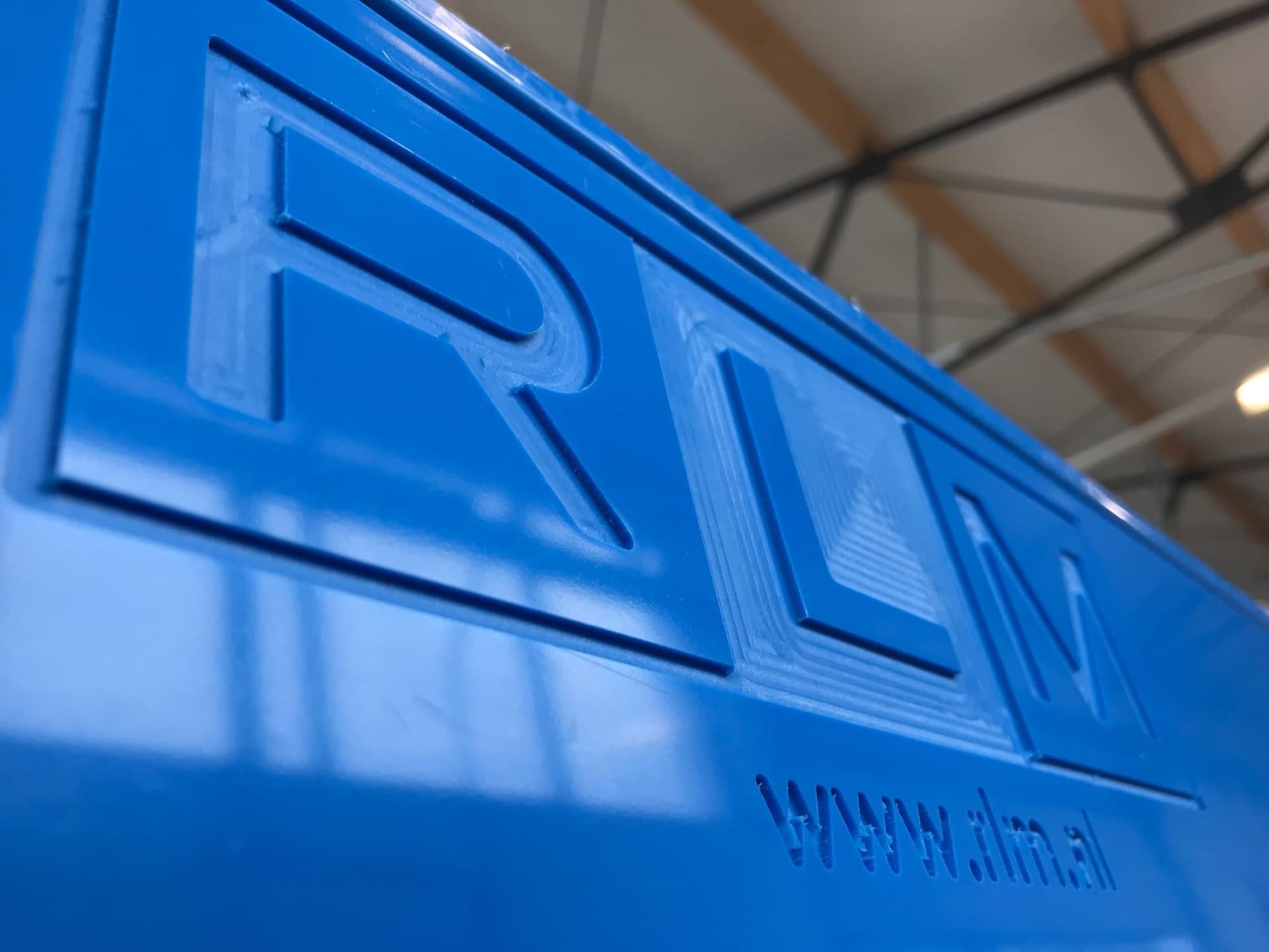 Het RLM-logo en het webadres, uitgefreesd in een blauwe kunststof plaat in de eigen werkplaats