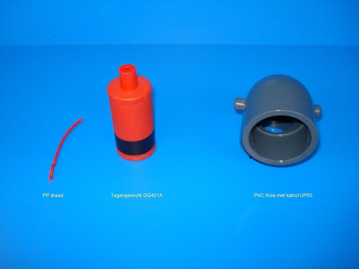 Onderdelen voor niveaumeting SFA op blauwe ondergrond: PP-draad, oranje tegengewicht GG401A en een grijze PVC-knie met katrol