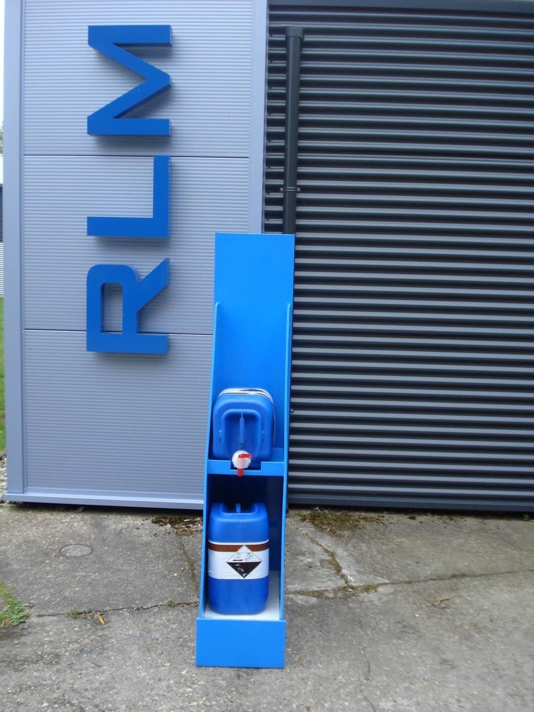 Smalle blauwe aftapkast met twee blauwe jerrycans boven elkaar, de bovenste met aftapkraan boven de onderste