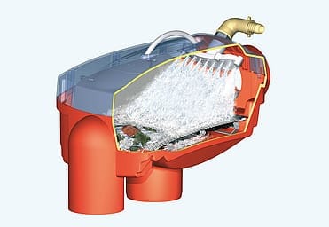 Rode GRAF-regenpijpfilter met doorzichtig deksel, gemonteerd op een verticale regenpijp, met water dat over de filterzeef stroomt