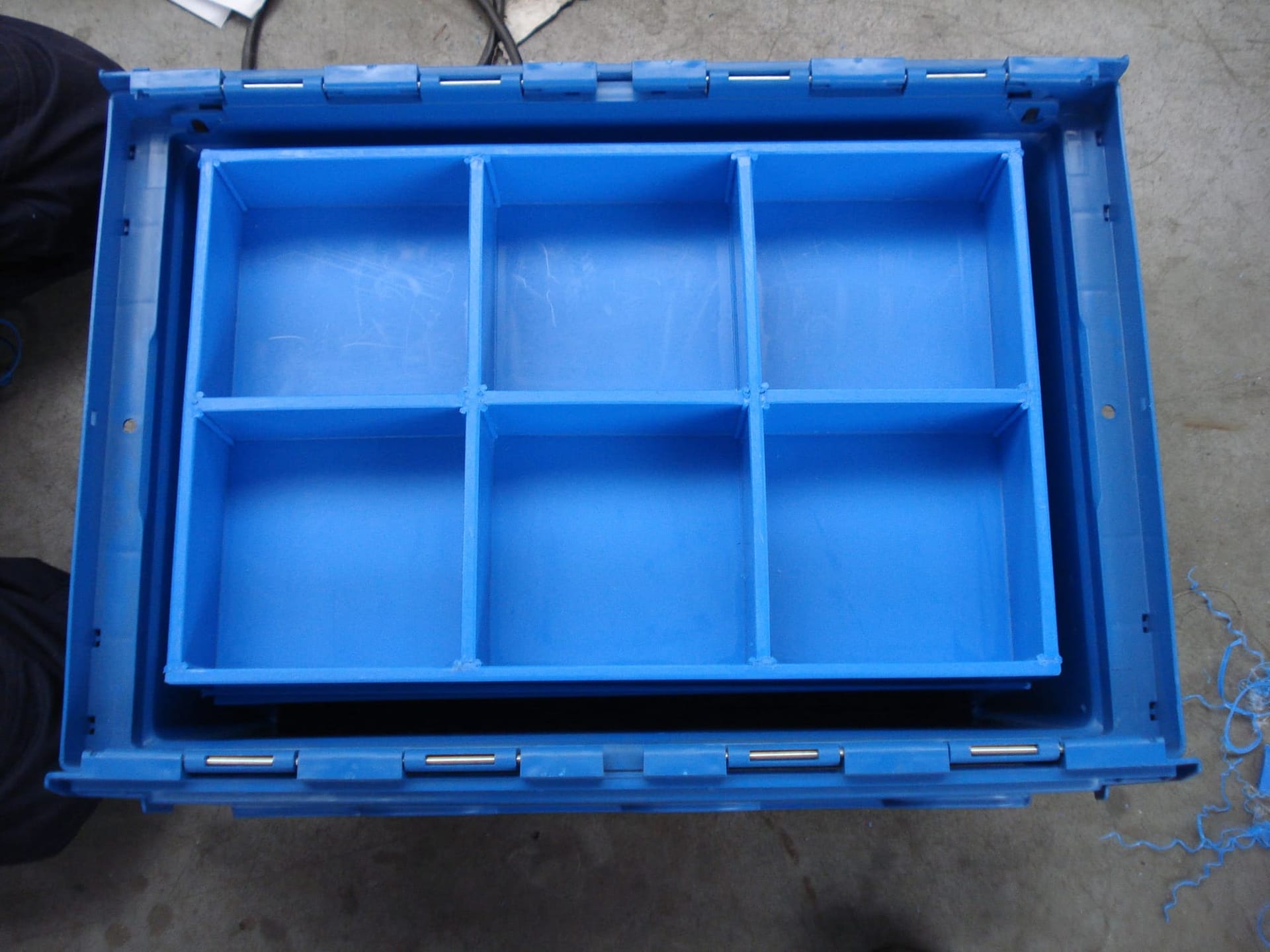 Blauwe kunststof transportbak met een op maat gelaste PE-inzet die de bak in zes vakken verdeelt