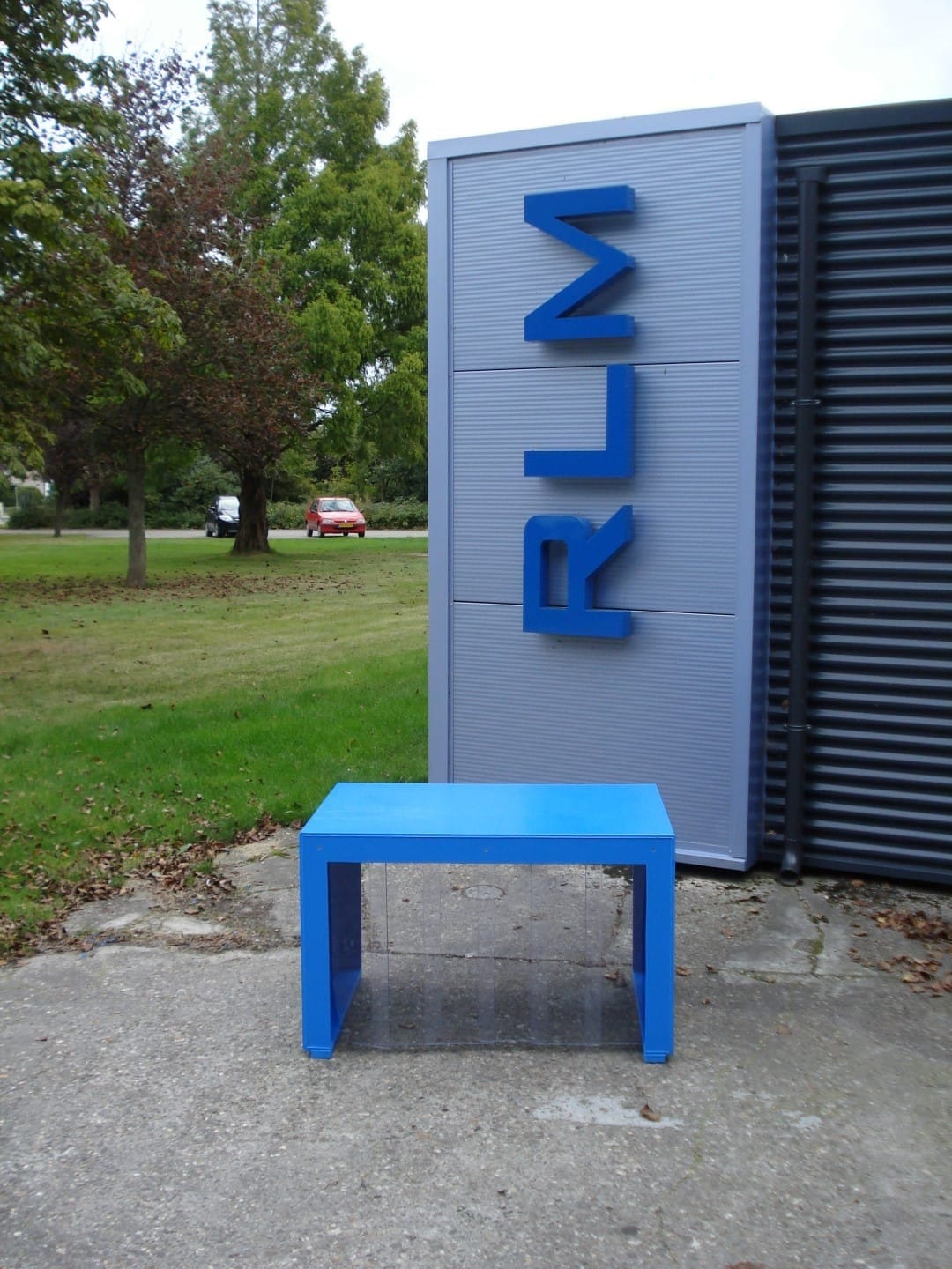 Blauwe kunststof tafel met vier poten, buiten voor de RLM-gevelletters