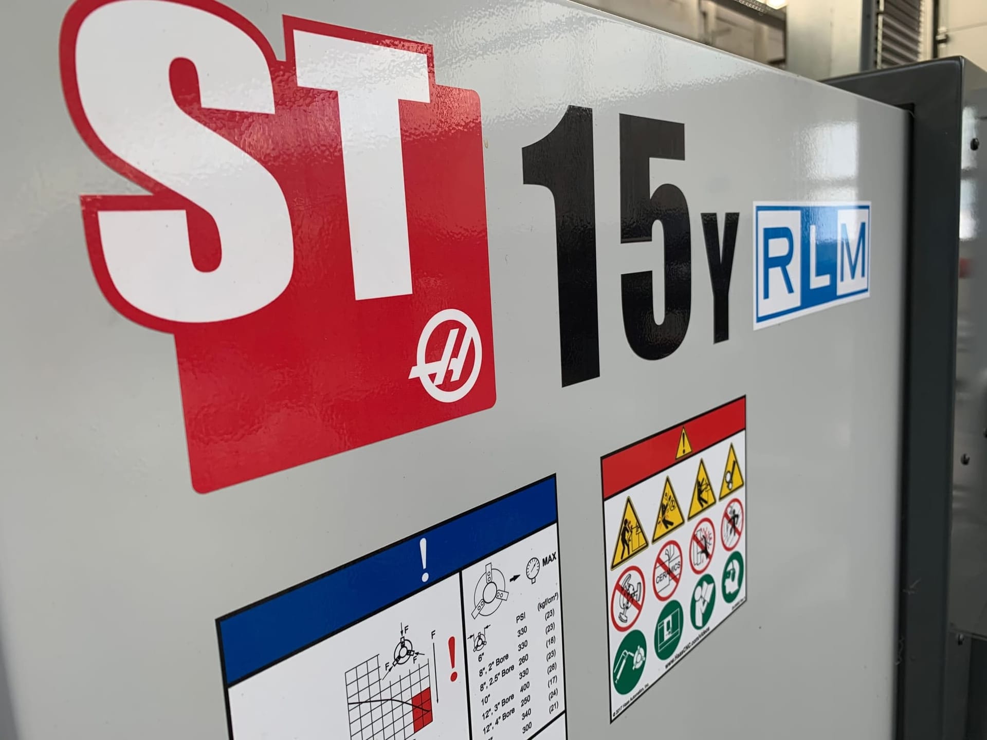 Bedieningszijde van de Haas ST-15Y CNC-draaibank met RLM-sticker en de instructiestickers eronder