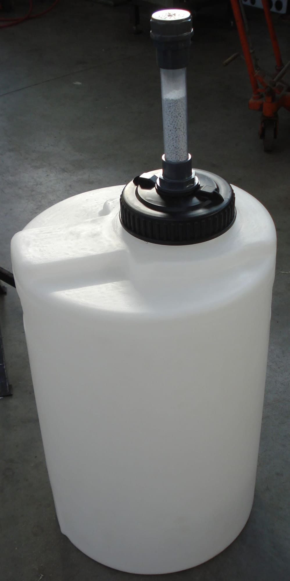 Zuurdampabsorber: een witte PE-tank met op het deksel een doorzichtige kolom gevuld met wit absorptiegranulaat