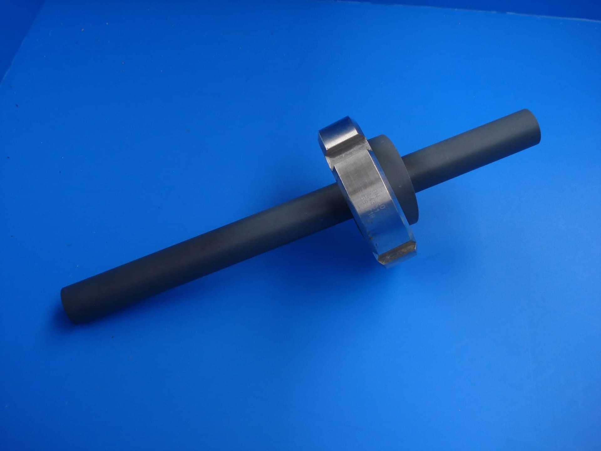 Injectieventiel van grijs PVC met een rvs wartelmoer, op blauwe ondergrond