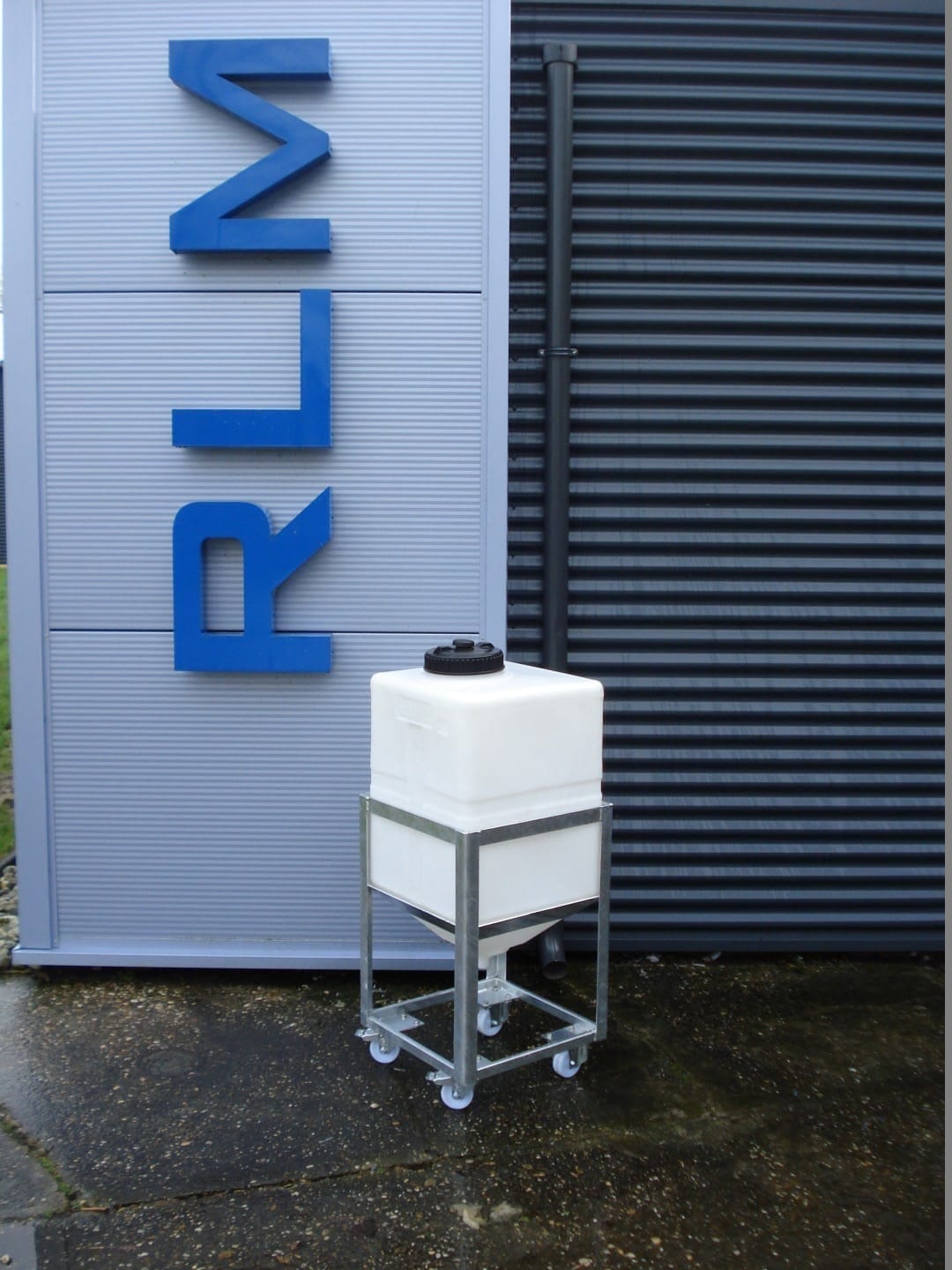 Witte vierkante PE-tank met conische bodem in een verzinkt frame op zwenkwielen, voor het pand van RLM